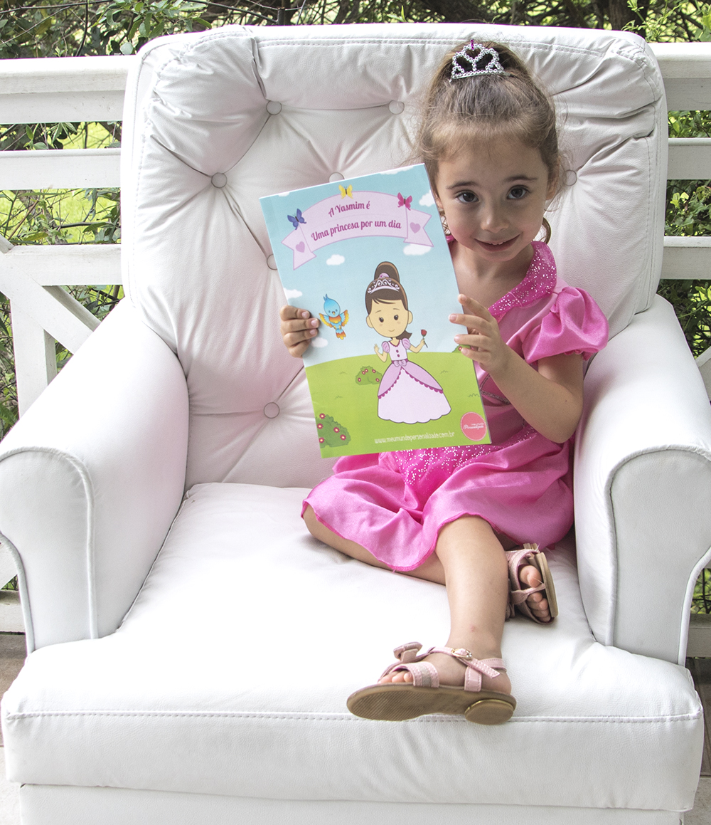 Menina segurando livro infantil personalizado Eu sou uma princesa por um dia